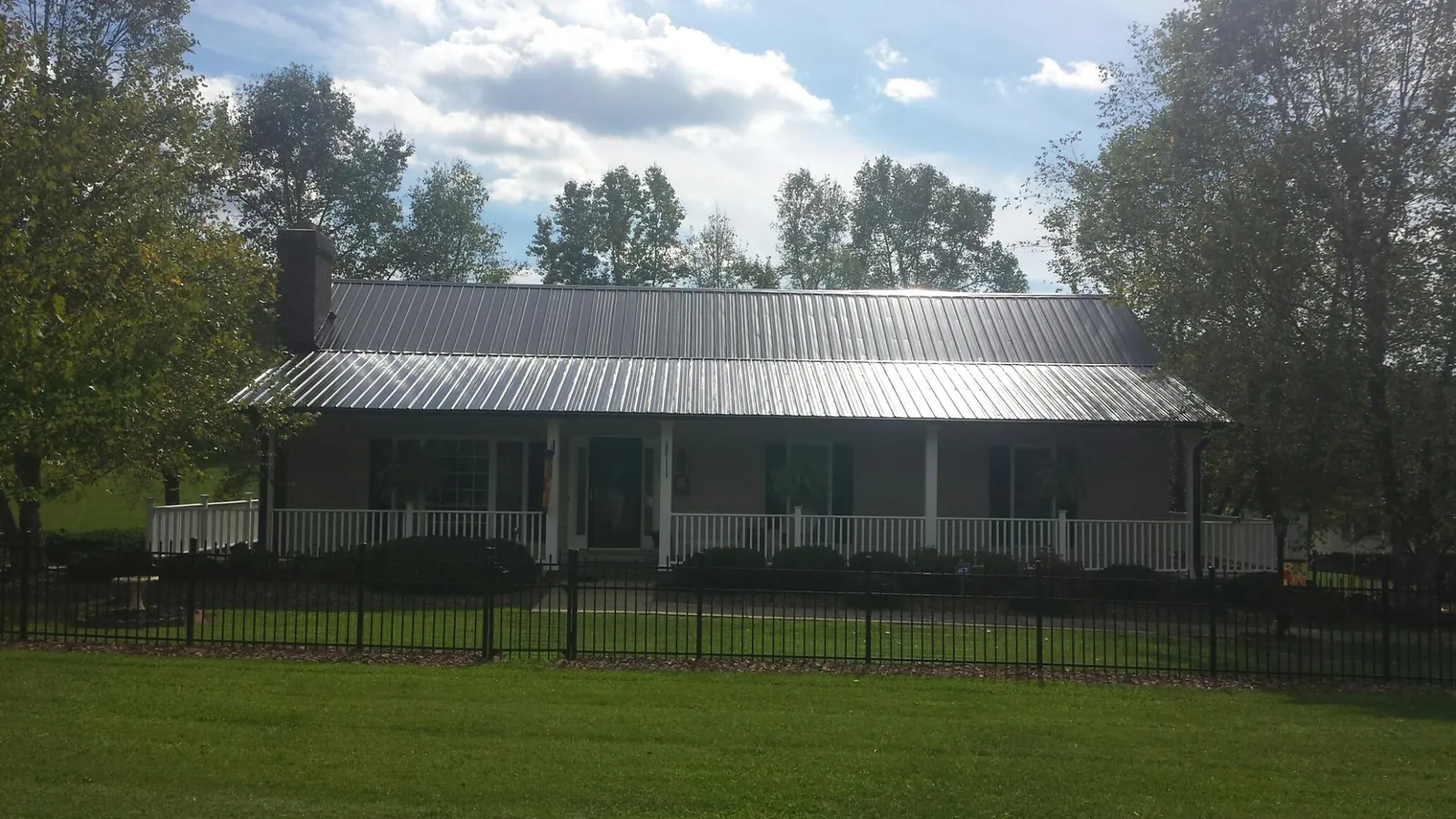 Gray metal roof on a brick ranch with a full width front porch — Gutter Guard Installation work by our crew in Fallbrook